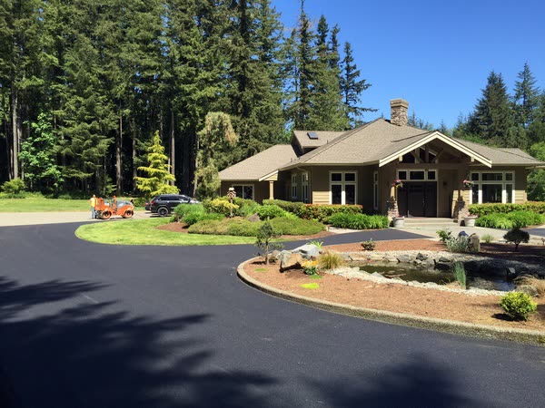 Finished circular asphalt driveway at a woodland home